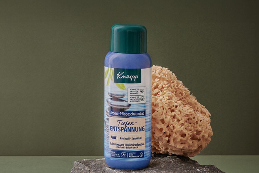 Láhev se sprchovým produktem od Kneipp a mořskou houbu na mytí