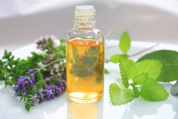 lahvička s aromatickým olejem, trs meduňky a levandule