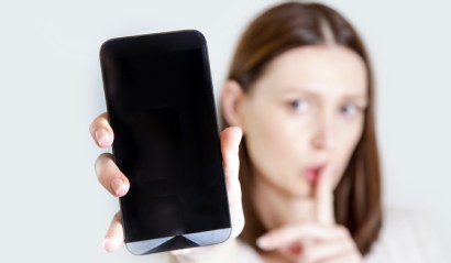 Žena před spaním přepíná svůj mobilní telefon do tichého režimu